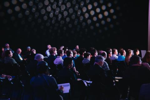 grupo de personas en un auditorio asistiendo a una ponencia