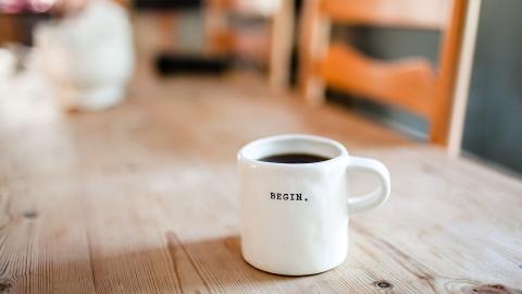 imagen de una taza de café con el texto "begin" inscrito en la taza