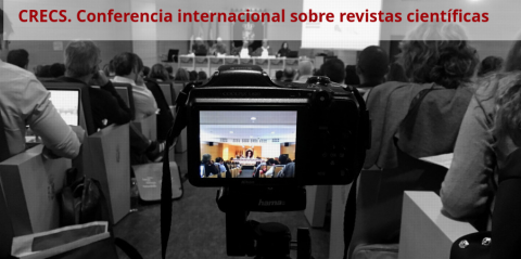 Imagen una sala con asistentes a una conferencia y una cámara grabando al ponente de la misma